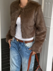 Detail view of women's short brown faux fur coat with a round neck and soft texture