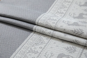 Macro shot of grey Jacquard fabric showing Christmas reindeer patterns and woven texture