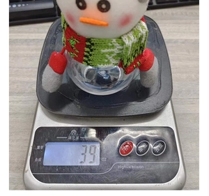Detail shot of a cute snowman candy jar on an electronic scale showing 39g weight