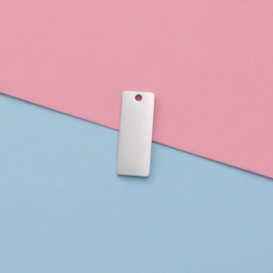 Close-up of a silver rectangular stainless steel tag with mirror finish for DIY jewelry