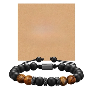 Detail of tiger eye and matte black beads bracelet with adjustable cord on gift card