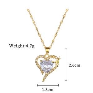 Detailed size view of gold heart pendant with cubic zirconia cross and star accents
