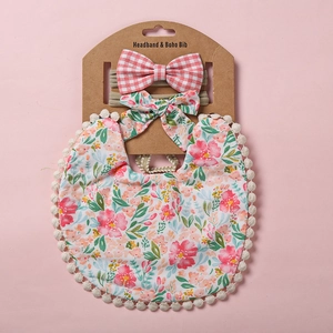 Bavoir floral pour bébé avec pompons et bandeaux à nœuds assortis sur rose