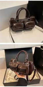 Detail of dark brown patent leather saddle bag with silver hardware and front pockets