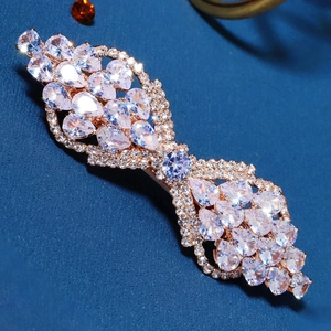 Close-up of golden hair clip with sparkling water-drop and round cubic zirconia stones