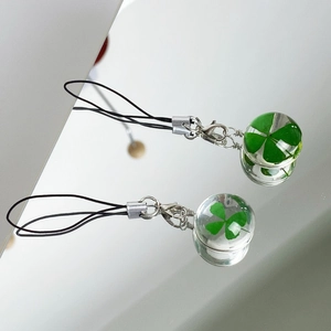 Macro detail of natural green four-leaf clover preserved in a transparent glass pendant
