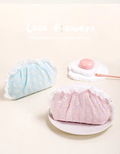 Detail of floral daisy makeup bags with white lace trim and secure zipper closure