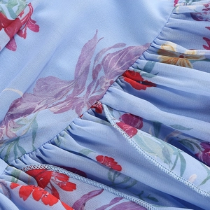 Makro-Detail des geblümten Chiffon-Stoffs mit Falten und feinen Nähten an einem Kleid