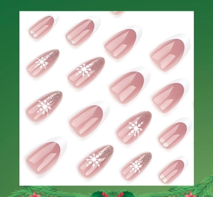 Detail view of festive white French press-on nails with glitter and snowflake patterns