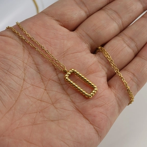 Macro shot of 18K gold plated stainless steel twisted rectangle pendant necklace detail