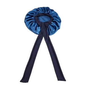 Detailed view of teal and dark blue satin sleep cap with long stretch ribbons for hair care