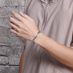 Close-up of minimalist silver stainless steel Cuban link bracelet on model wrist