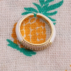 Macro shot of an adjustable gold-plated ring with white enamel and micro-pave zircons