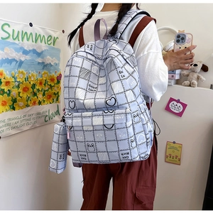 Detail of blue plaid school backpack with cute rabbit illustration and matching pencil case