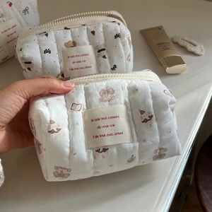 Close-up of quilted cotton makeup bag with cute bear patterns and French text label