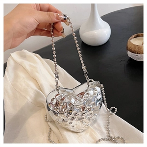 Dettaglio della mini borsa a cuore argento con trama martellata e catena a sfere
