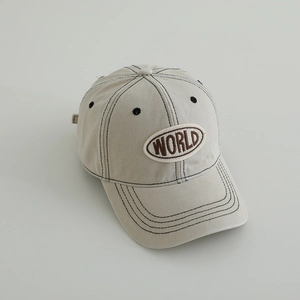 Detailed close-up of beige cotton twill baseball cap showing black stitching and World embroidery