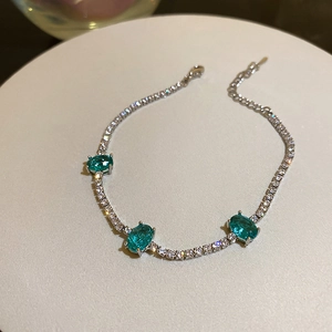 Detail showing three blue oval gemstones set in a silver metal chain on a display stand
