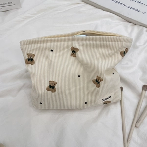 Detailed view of cream corduroy makeup bag featuring bear patterns and zip closure