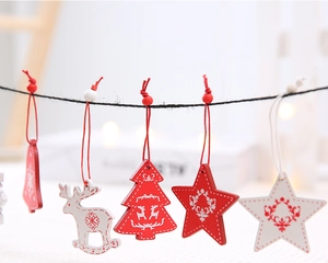 Close-up of red and white wooden Christmas ornaments with reindeer and bell motifs