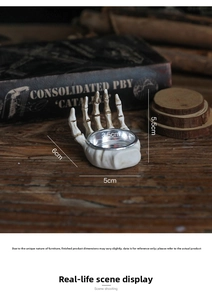 Detailed view of skeleton hand candle holder with retro finish and dimensions of 5.5x5cm