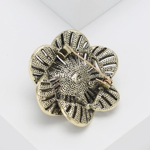 Detailed back view of vintage flower brooch showing safety clasp and hollow metal texture