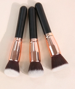 Close-up of flat foundation brushes with rose gold ferrules and black handles