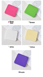 Macro shot of colorful mini folding makeup mirrors in rose, green, white, yellow, and purple