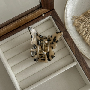 Top view of butterfly hair claw clip with tortoise shell texture in velvet jewelry box