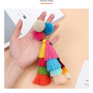 Detail of colorful tiered tassel keychain with multi-color pompoms and golden metal ring