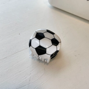 Detailed close-up of a soccer ball shaped hair claw clip in classic black and white finish