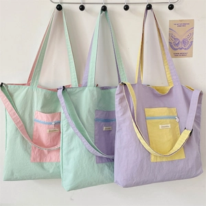 Macro detail of canvas tote bag showing colorful pockets and adjustable shoulder strap