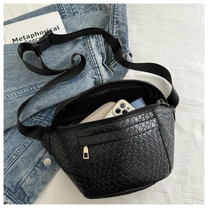 Detailed view of black woven chest bag with adjustable strap and interior storage