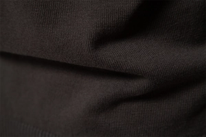 Macro shot of high-density knitted fabric texture showing premium soft dark olive material