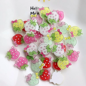 Macro view of colorful resin strawberry charms with bows for DIY phone case crafts