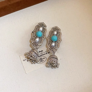 Detailed view of vintage ethnic silver earrings with turquoise, pearls and jhumka bells