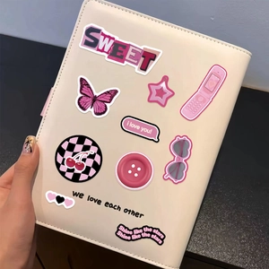 Close-up of Y2K style pink stickers with heart and butterfly designs on a notebook