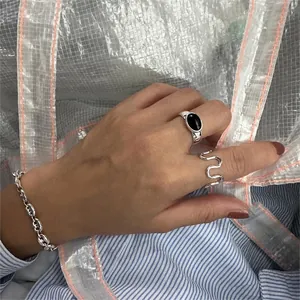 Detailed view of a silver wide ring set with black onyx and wave pattern ring