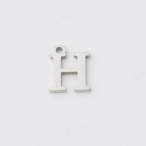 Close-up of a silver stainless steel H letter pendant with a polished mirror finish