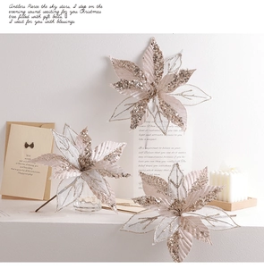 Detailed view of champagne gold artificial poinsettias with glitter and mesh texture