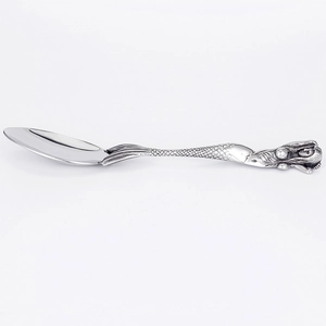 Close-up of a silver mermaid handle spoon with detailed mermaid tail carving on metal