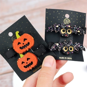 Halloween hair clips set featuring orange felt pumpkin and black sequin bat for kids