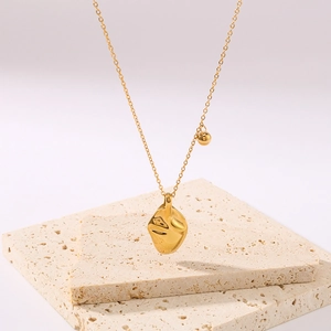 Elegant 18k gold plated leaf pendant necklace with irregular wavy design on stone base