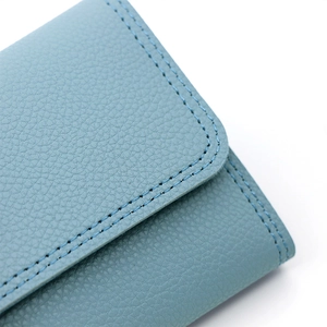 Detailed macro view of blue pebble grain leather texture with neat double stitching