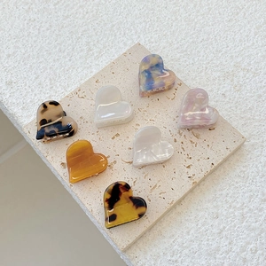 Detail of assorted mini heart-shaped acetate hair claws in various marble and tortoiseshell patterns