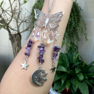 Detail of butterfly suncatcher with amethyst stones and celestial charms on arm