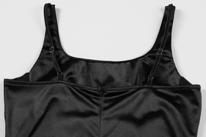 Detail of black satin camisole showing adjustable shoulder straps and silky fabric texture