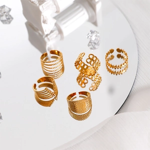 Detail of 18k gold plated stainless steel open ring set with various textured patterns