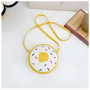 Close-up of yellow donut-shaped kids crossbody bag with colorful sprinkles and Hello text