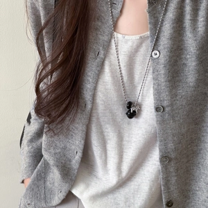 Tiger eye bell pendant necklace with silver bead chain shown on a grey knit sweater